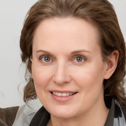 Joyful white young-adult female with medium  brown hair and blue eyes