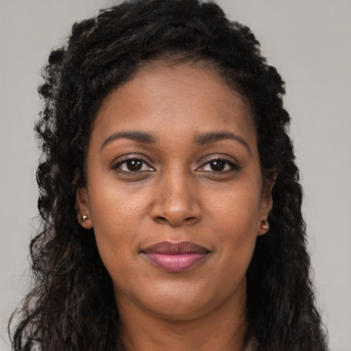 Joyful black adult female with long  black hair and brown eyes