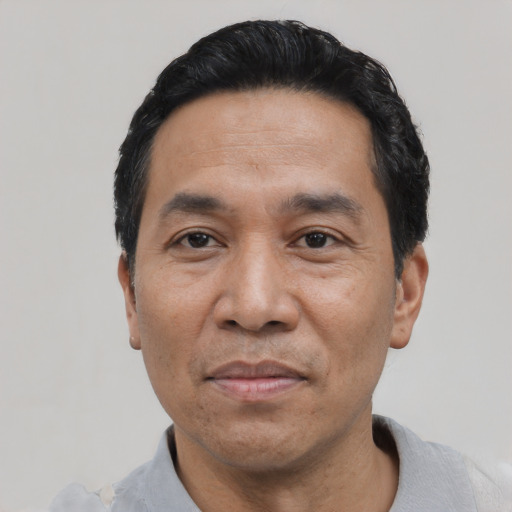Joyful asian adult male with short  black hair and brown eyes