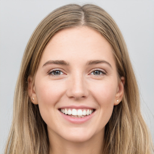 Joyful white young-adult female with long  brown hair and grey eyes