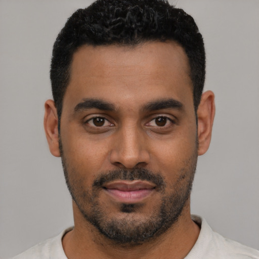Joyful black young-adult male with short  black hair and brown eyes
