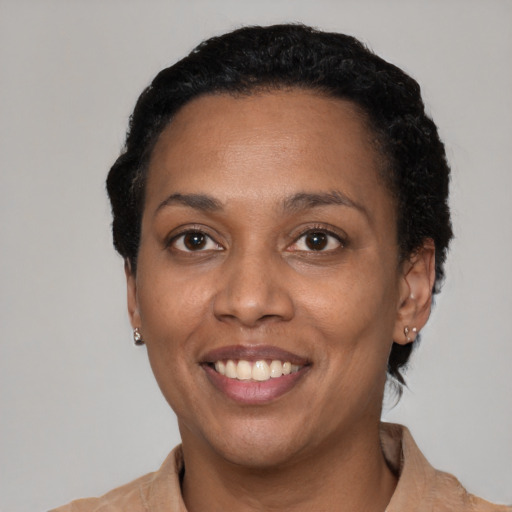 Joyful black adult female with short  black hair and brown eyes