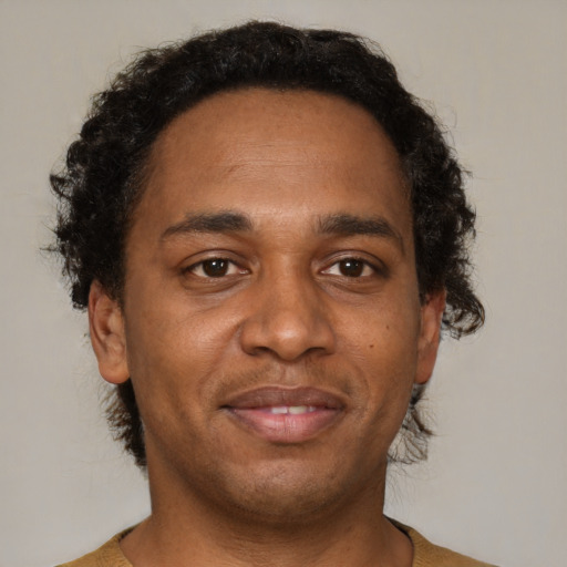 Joyful black adult male with short  brown hair and brown eyes