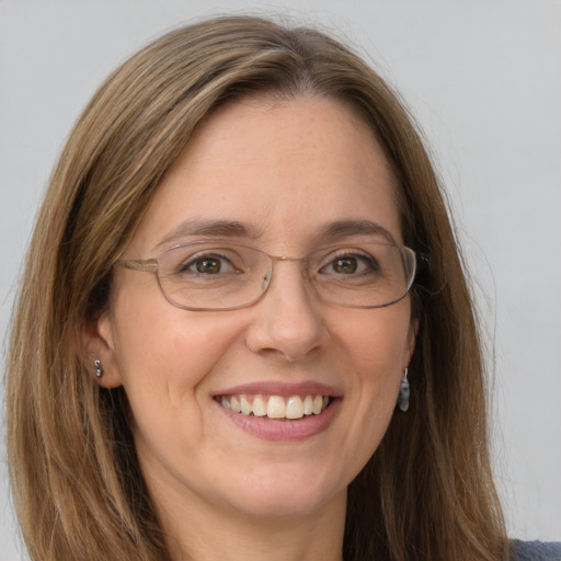 Joyful white adult female with long  brown hair and grey eyes