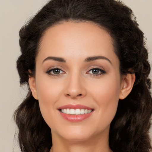 Joyful white young-adult female with long  brown hair and brown eyes