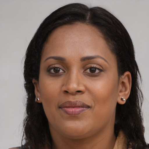 Joyful black young-adult female with long  brown hair and brown eyes