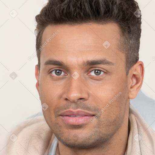 Joyful white young-adult male with short  brown hair and brown eyes