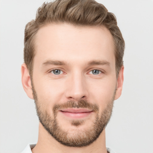 Joyful white young-adult male with short  brown hair and grey eyes