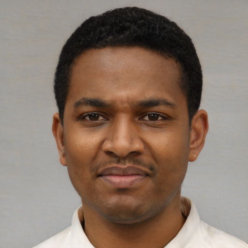 Joyful black young-adult male with short  black hair and brown eyes