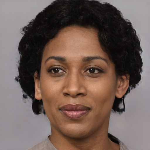 Joyful black adult female with short  black hair and brown eyes