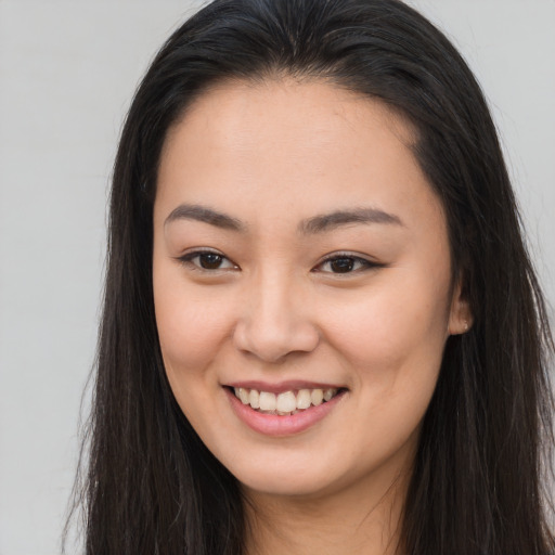 Joyful asian young-adult female with long  brown hair and brown eyes