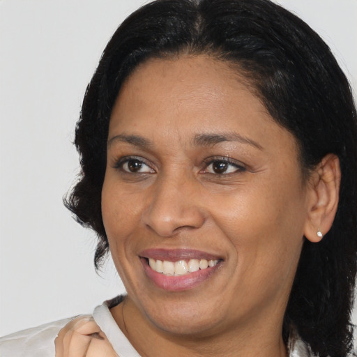 Joyful black adult female with medium  brown hair and brown eyes