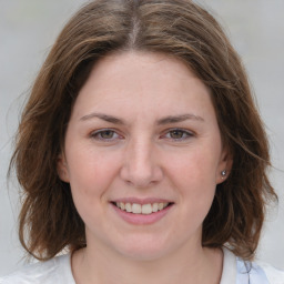 Joyful white young-adult female with medium  brown hair and blue eyes