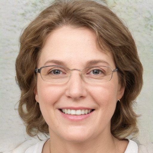 Joyful white adult female with medium  brown hair and green eyes