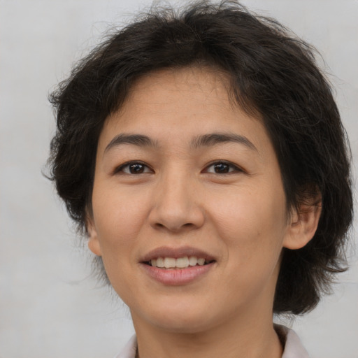 Joyful latino adult female with medium  brown hair and brown eyes