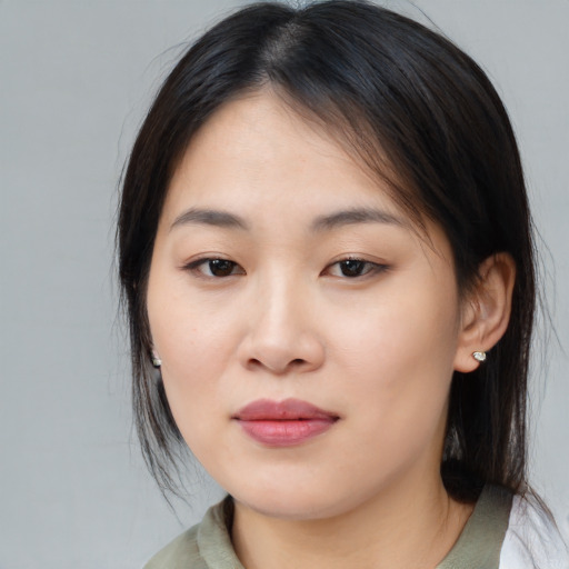 Joyful asian young-adult female with medium  brown hair and brown eyes