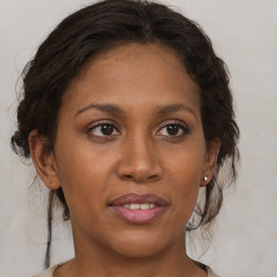 Joyful black adult female with medium  brown hair and brown eyes