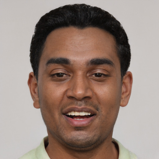 Joyful black young-adult male with short  black hair and brown eyes