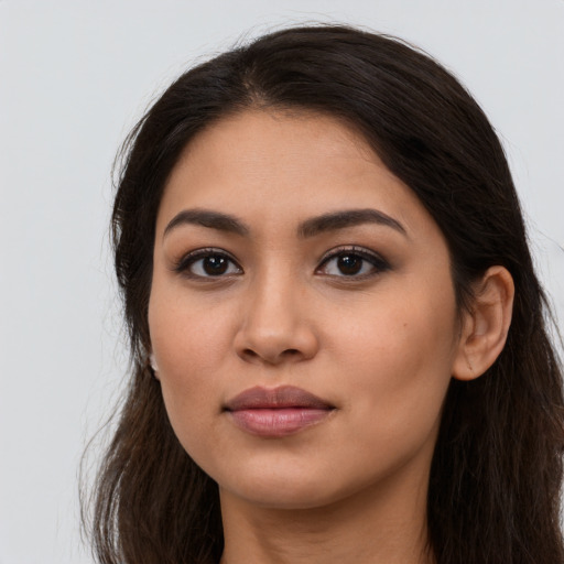 Joyful latino young-adult female with long  brown hair and brown eyes