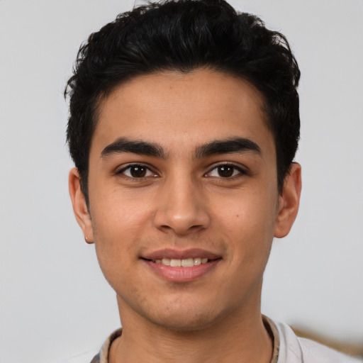 Joyful latino young-adult male with short  brown hair and brown eyes