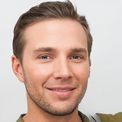 Joyful white young-adult male with short  brown hair and grey eyes