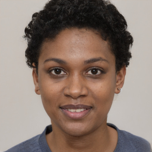 Joyful black young-adult female with short  black hair and brown eyes