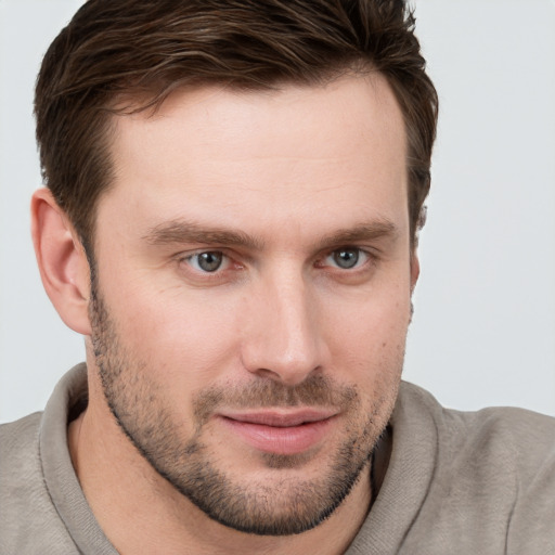 Joyful white young-adult male with short  brown hair and grey eyes