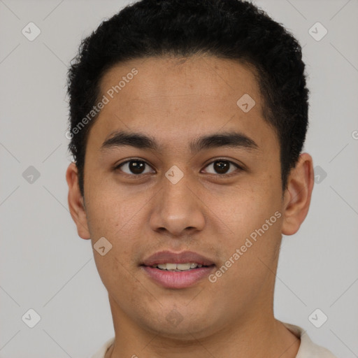 Joyful latino young-adult male with short  brown hair and brown eyes