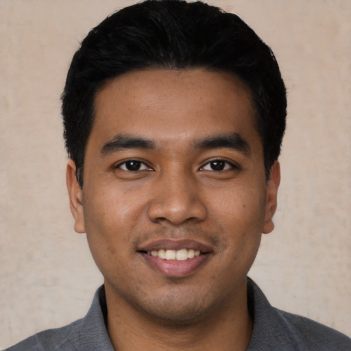 Joyful latino young-adult male with short  black hair and brown eyes