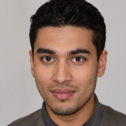 Joyful latino young-adult male with short  black hair and brown eyes