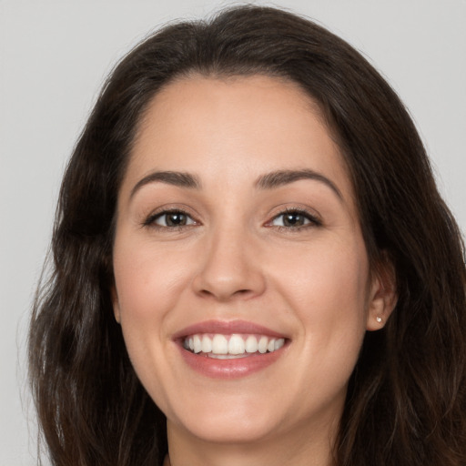 Joyful white young-adult female with long  brown hair and brown eyes