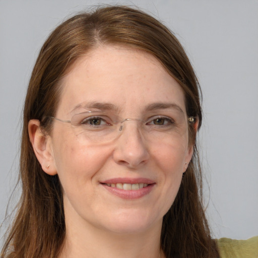 Joyful white adult female with long  brown hair and grey eyes