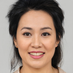 Joyful asian young-adult female with medium  brown hair and brown eyes