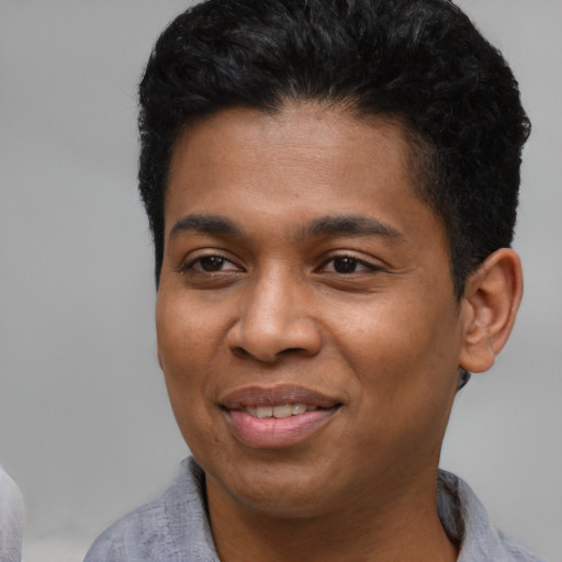 Joyful black young-adult male with short  black hair and brown eyes