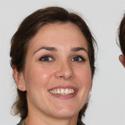 Joyful white young-adult female with medium  brown hair and grey eyes