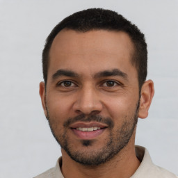 Joyful white young-adult male with short  black hair and brown eyes