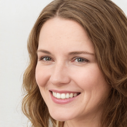 Joyful white young-adult female with long  brown hair and green eyes