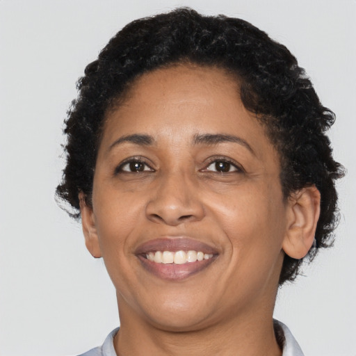 Joyful black adult female with short  black hair and brown eyes