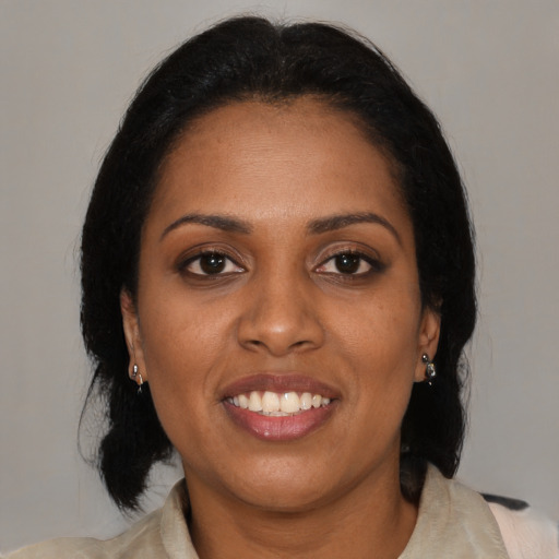 Joyful black young-adult female with medium  brown hair and brown eyes