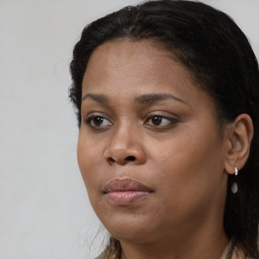 Joyful black young-adult female with long  black hair and brown eyes