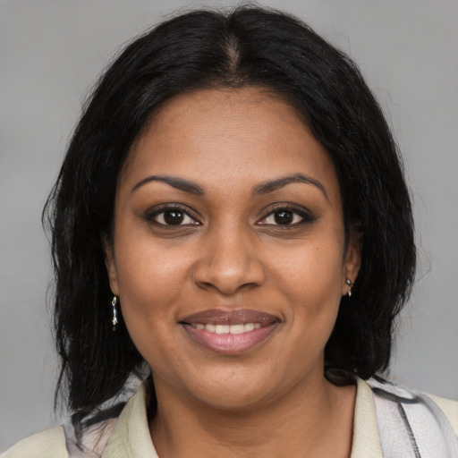 Joyful black young-adult female with medium  brown hair and brown eyes