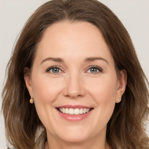 Joyful white adult female with medium  brown hair and brown eyes