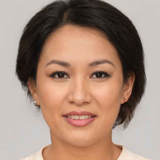 Joyful asian adult female with medium  brown hair and brown eyes