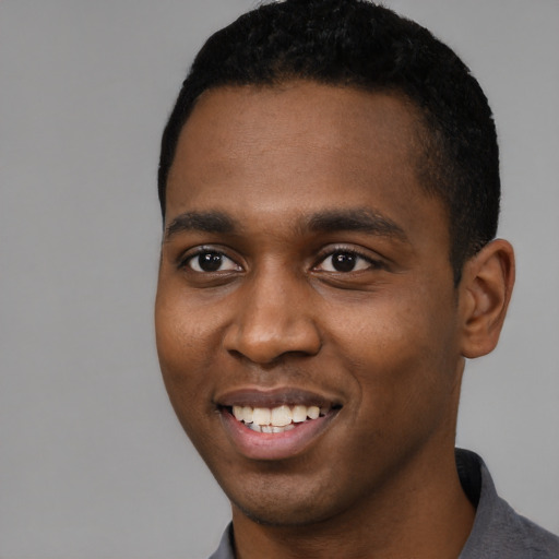 Joyful black young-adult male with short  black hair and brown eyes