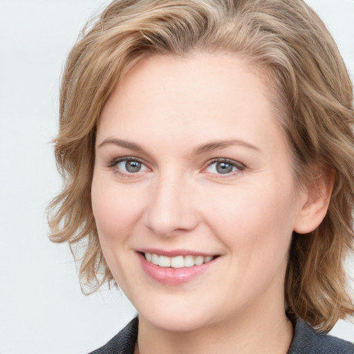 Joyful white young-adult female with medium  brown hair and blue eyes