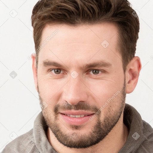 Joyful white young-adult male with short  brown hair and grey eyes