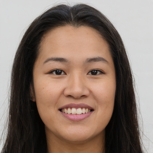 Joyful asian young-adult female with long  brown hair and brown eyes