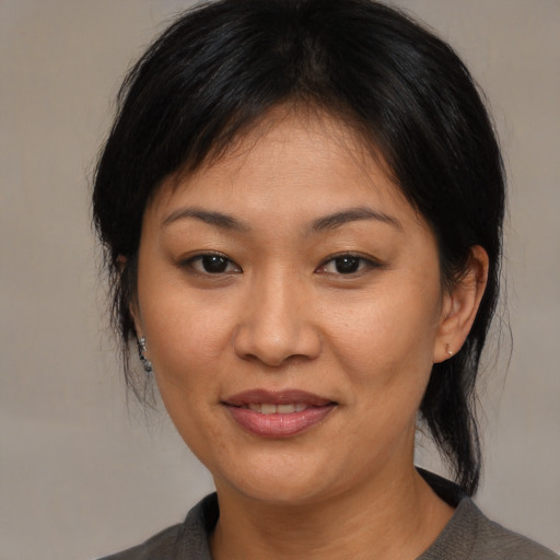 Joyful asian adult female with medium  brown hair and brown eyes