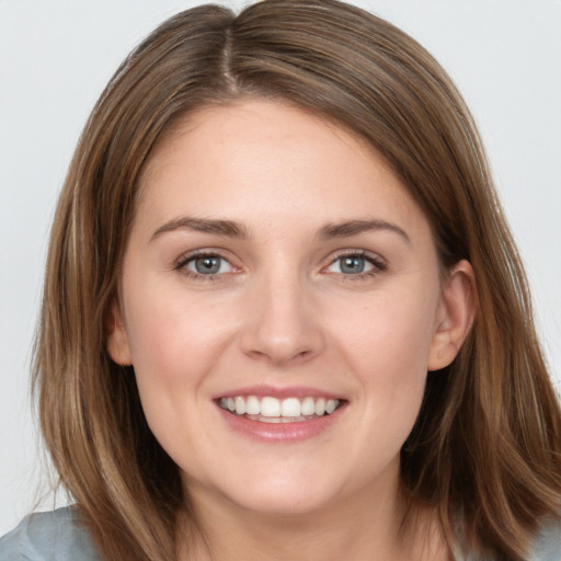 Joyful white young-adult female with long  brown hair and grey eyes