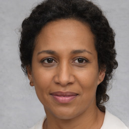 Joyful black adult female with medium  brown hair and brown eyes